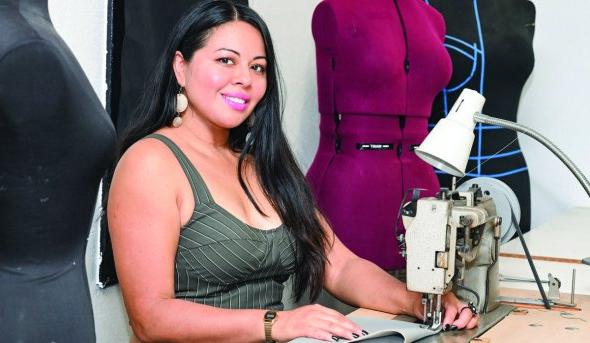 a woman sits at a sewing machine 