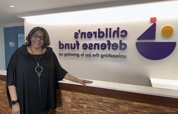 a woman stands in front of a sign 